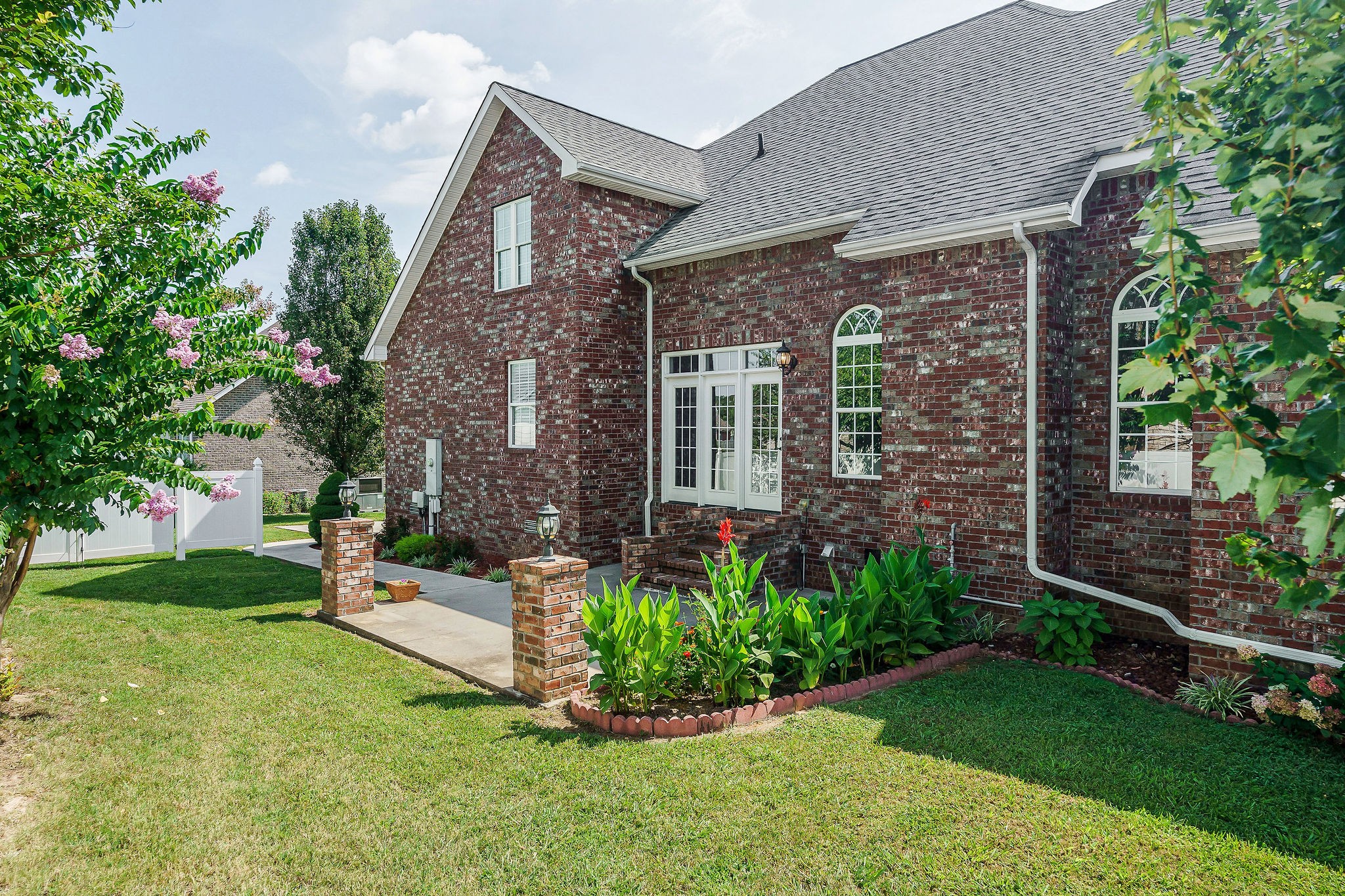 a front view of a house with a garden and trees