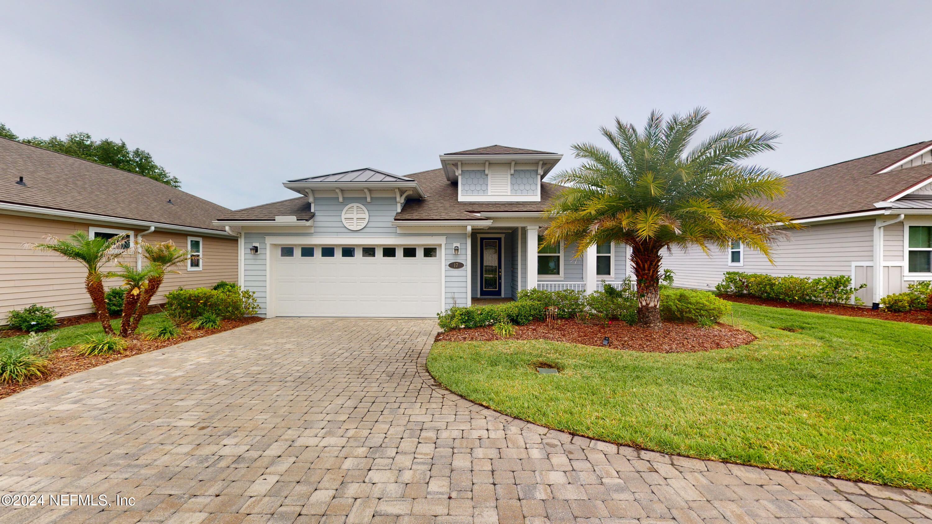 a front view of a house with a yard and potted plants