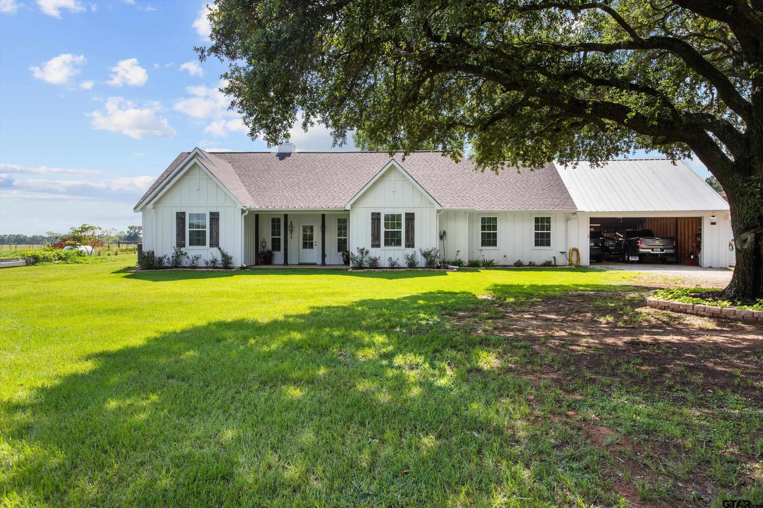 a front view of a house with yard and green space