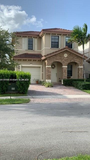 a front view of a house with a yard and potted plants