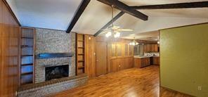 a view of a hallway with wooden floor and a fireplace