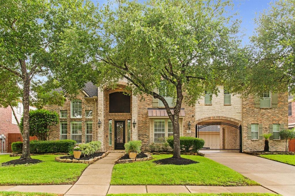 a front view of a house with yard and green space