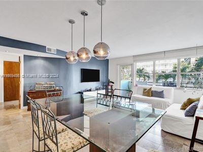 a living room with furniture a flat screen tv and a large window