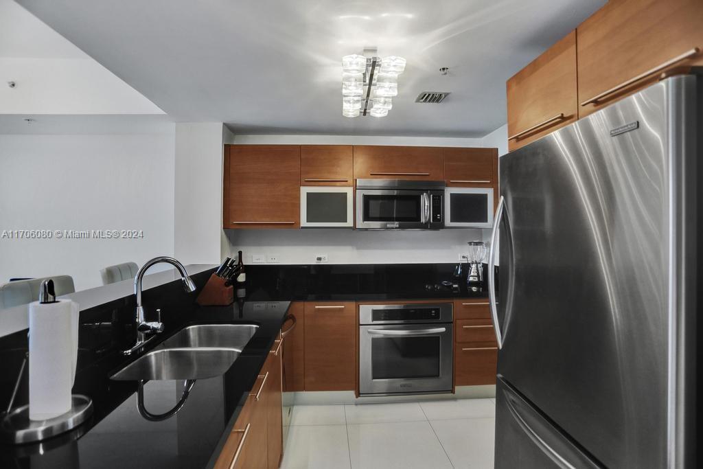 a kitchen with granite countertop stainless steel appliances and wooden cabinets