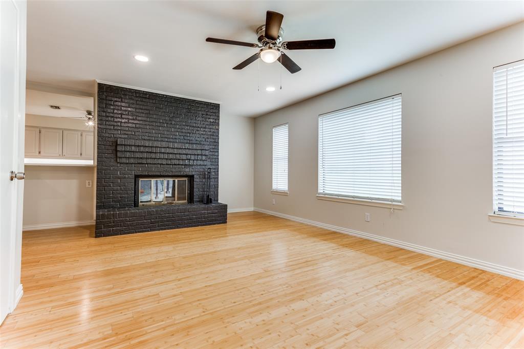 a view of empty room with wooden floor and fireplace