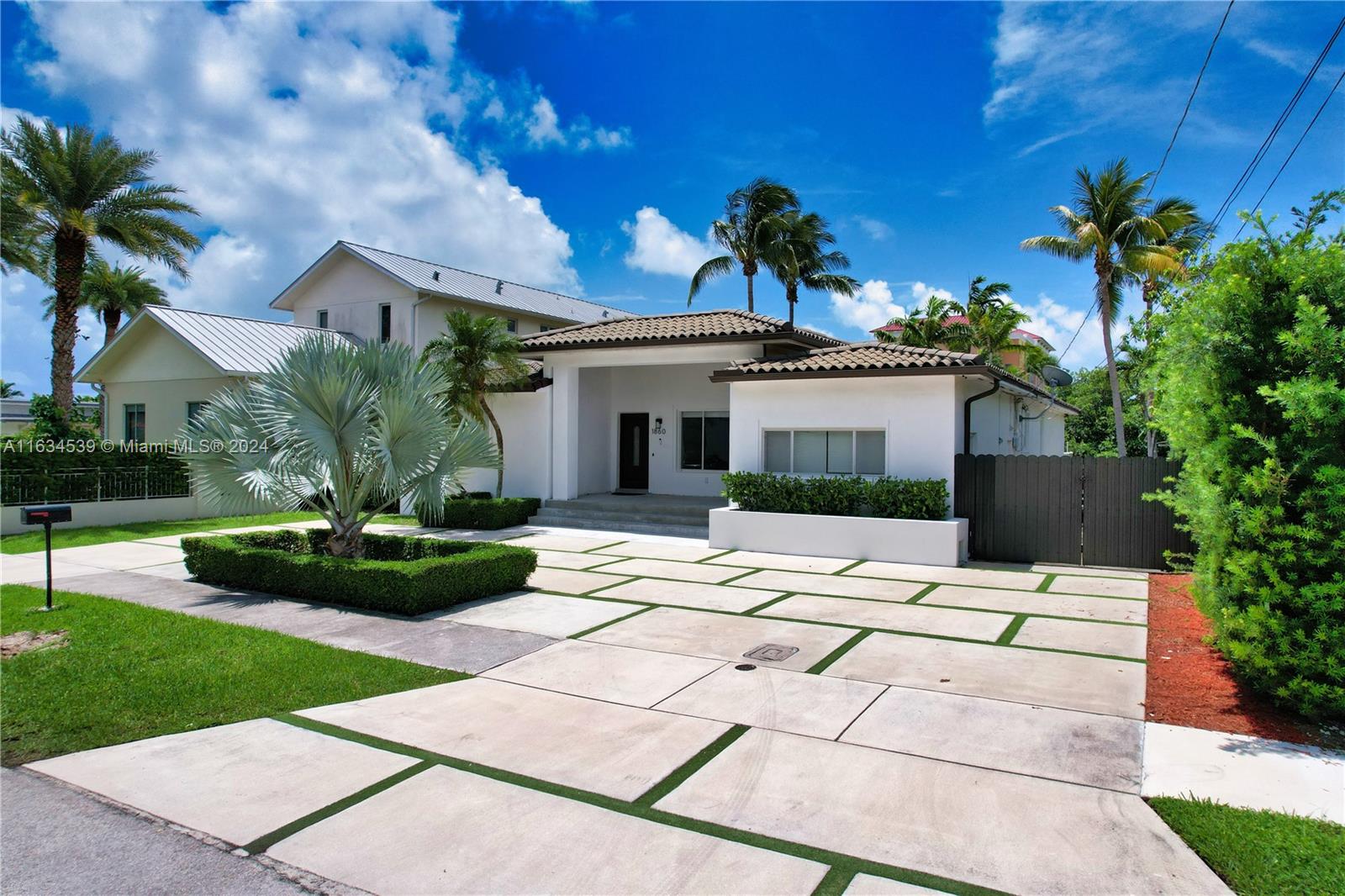 a view of a house with a yard and potted plants