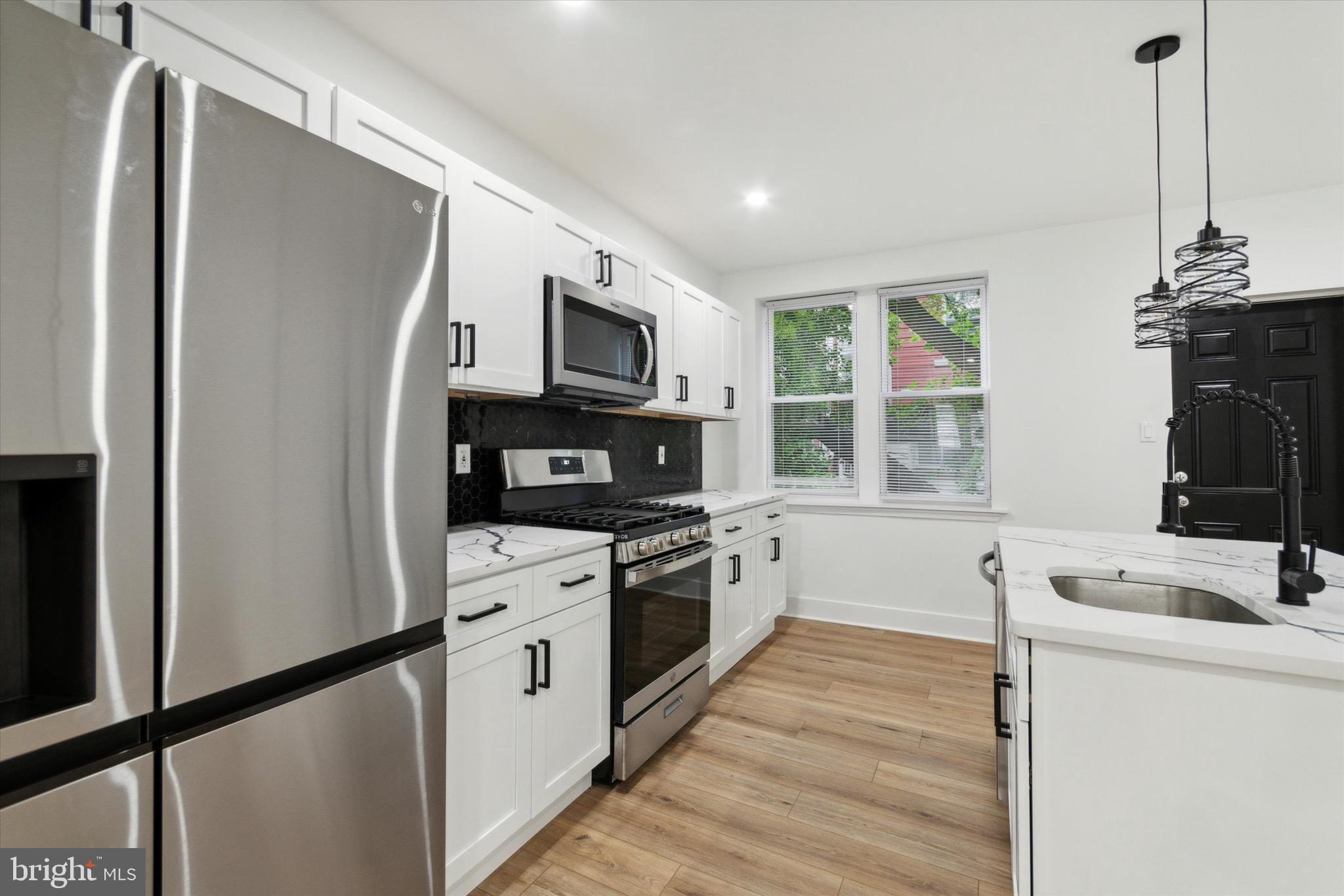 a kitchen with stainless steel appliances a stove microwave and sink