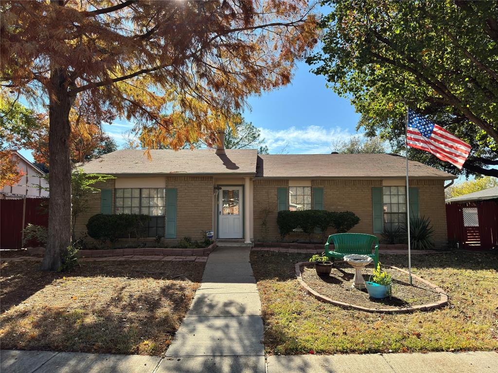 a front view of a house with a yard outdoor seating and covered with trees