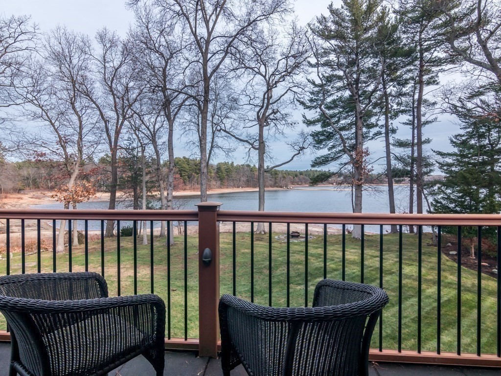 a view of roof deck with large trees and wooden fence