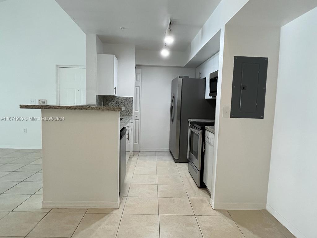 a kitchen with stainless steel appliances granite countertop a refrigerator and a stove