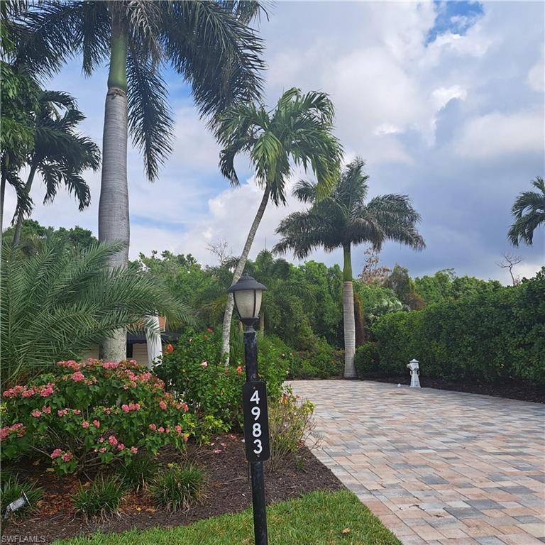 a front view of a house with a yard and potted plants