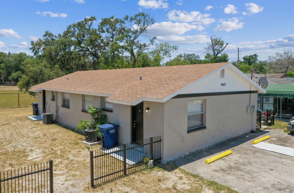 a aerial view of a house with table and chairs under an umbrella