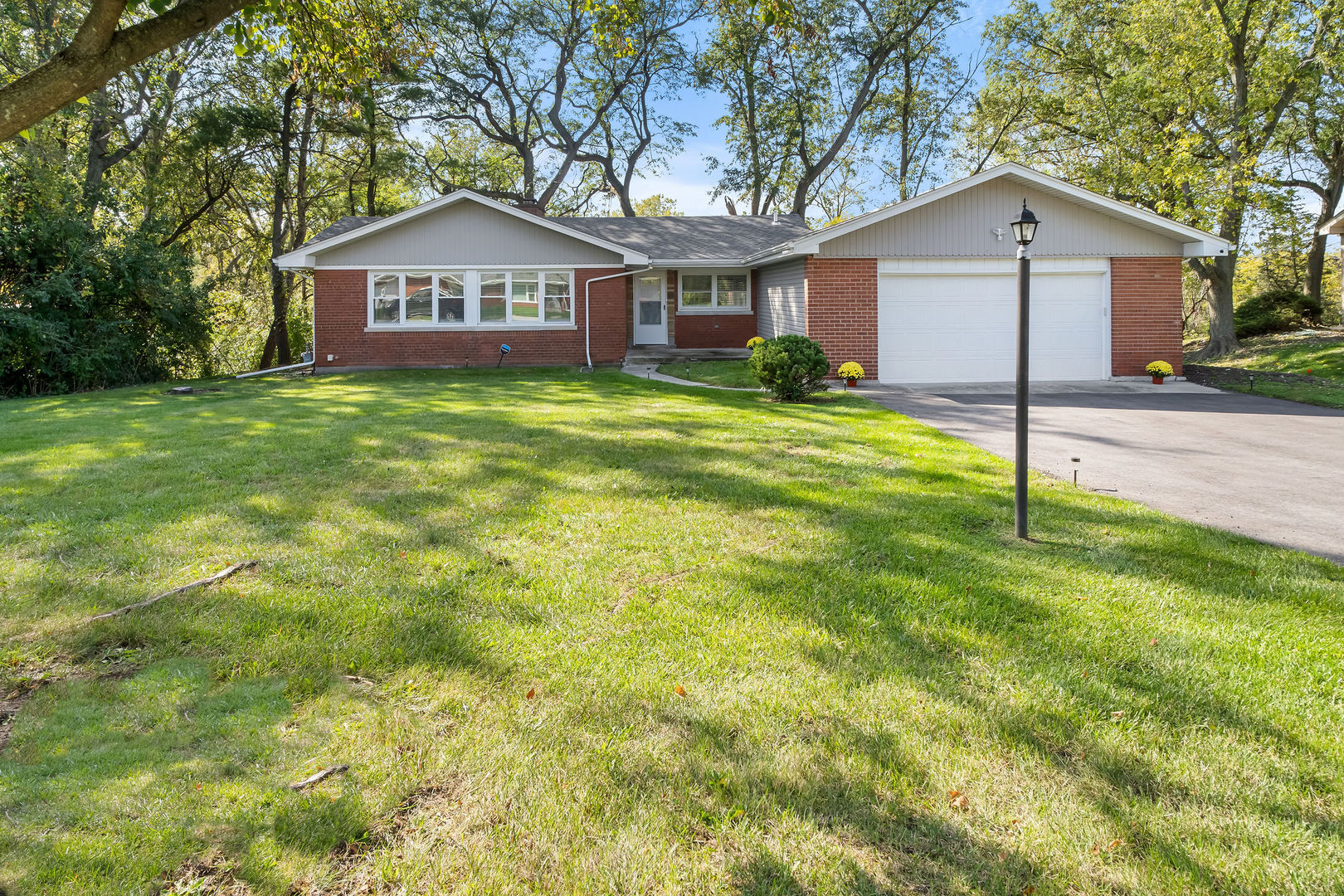 a front view of a house with a yard and trees