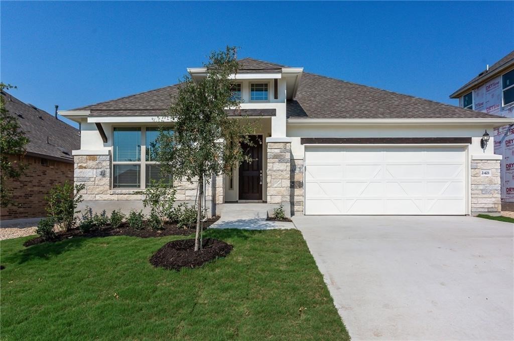 a front view of a house with a yard and garage