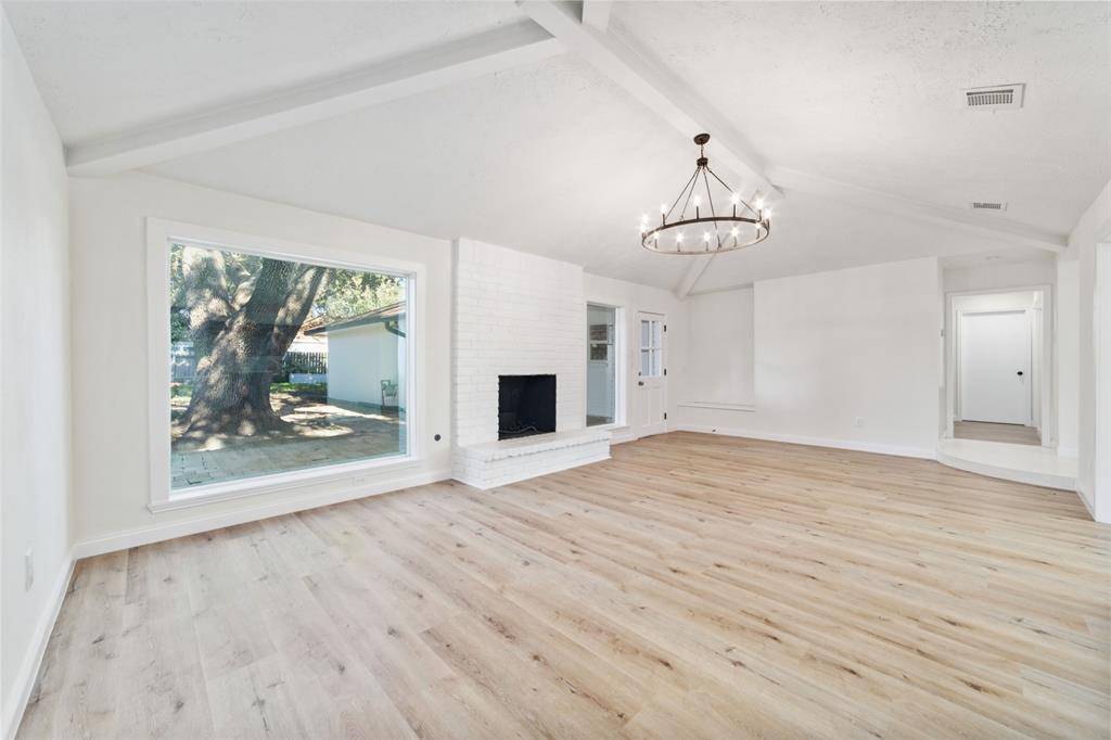 a view of empty room with wooden floor and fireplace