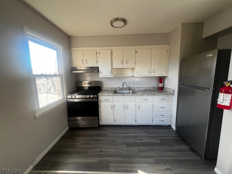 a kitchen with a refrigerator stove and white cabinets