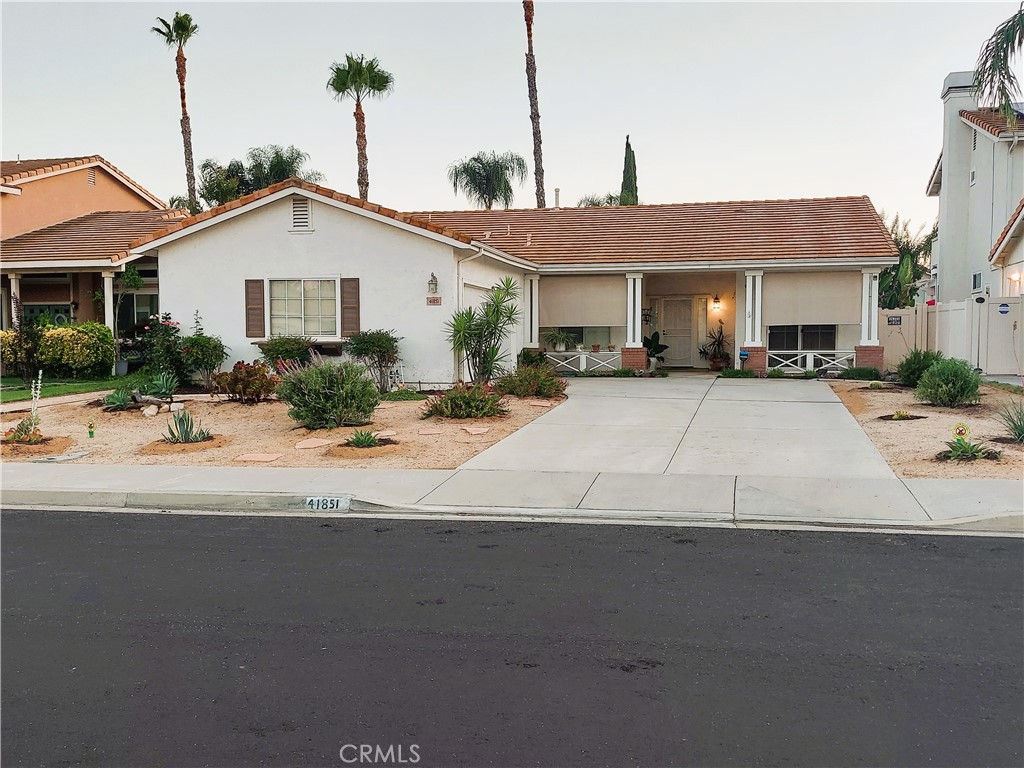 a front view of a house with yard and parking