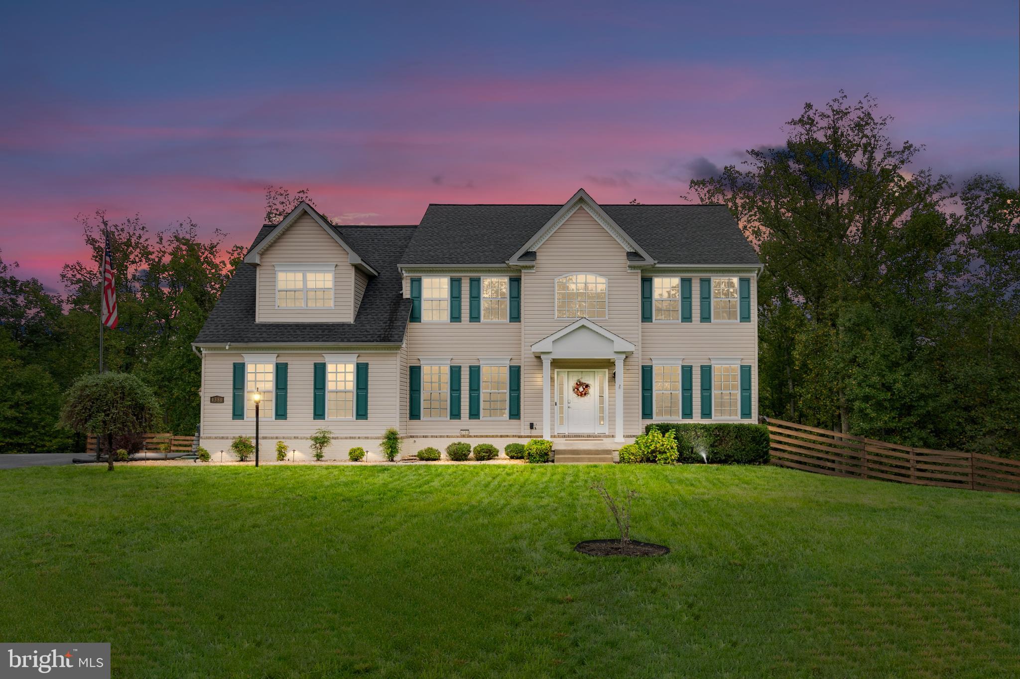 a front view of a house with a yard and trees