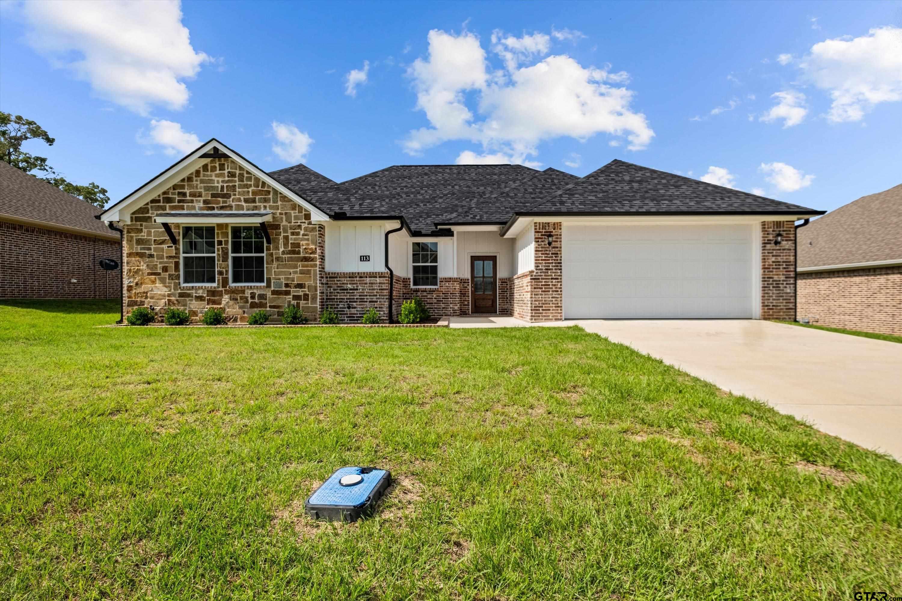 a front view of a house with yard and green space