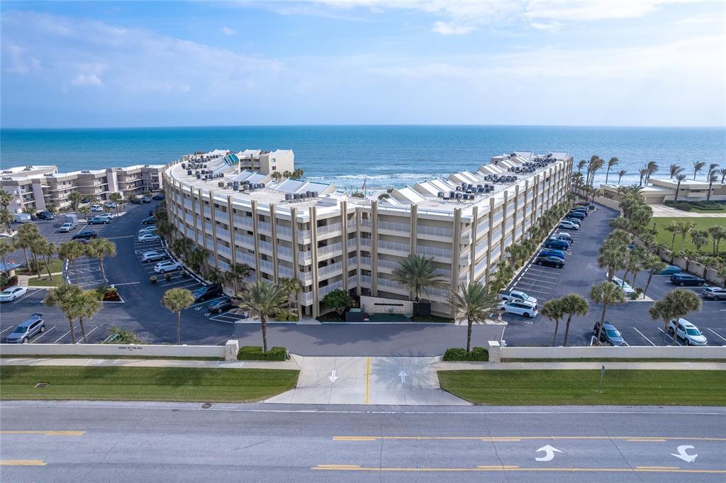 a view of buildings with yard and ocean view