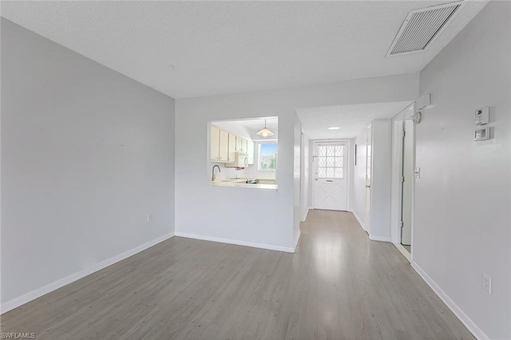 Unfurnished living room with hardwood / wood-style floors and sink