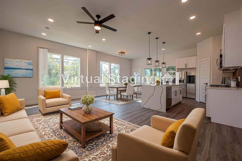 a living room with furniture kitchen area and a large window