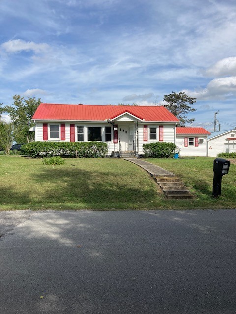 a view of a big house with a big yard and large trees