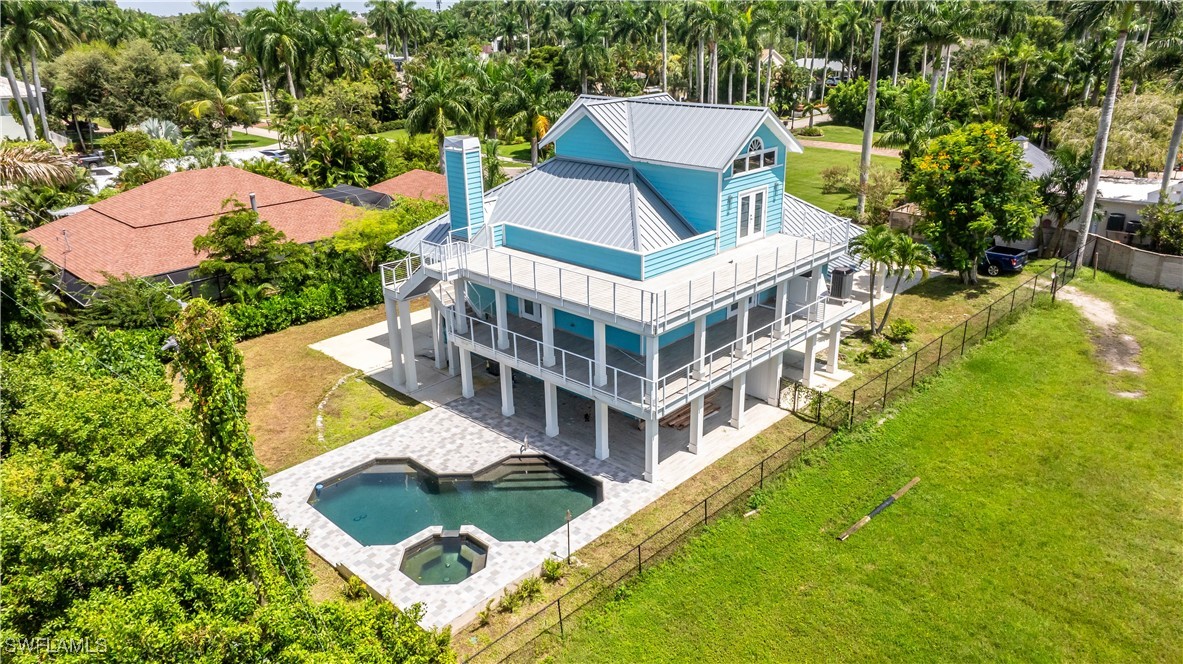 a aerial view of a house with swimming pool and large trees