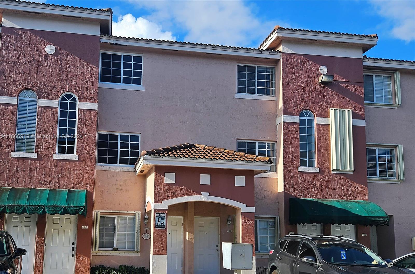 a front view of a residential apartment building with a yard