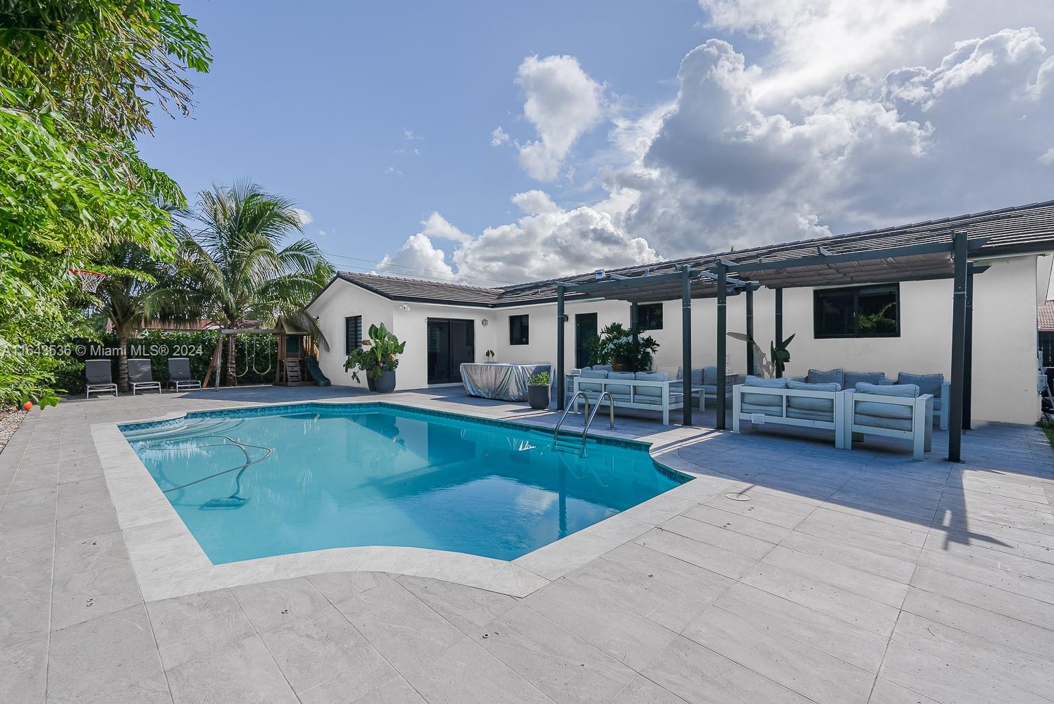 a view of a house with swimming pool and sitting area