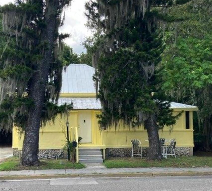 a front view of a house with a tree