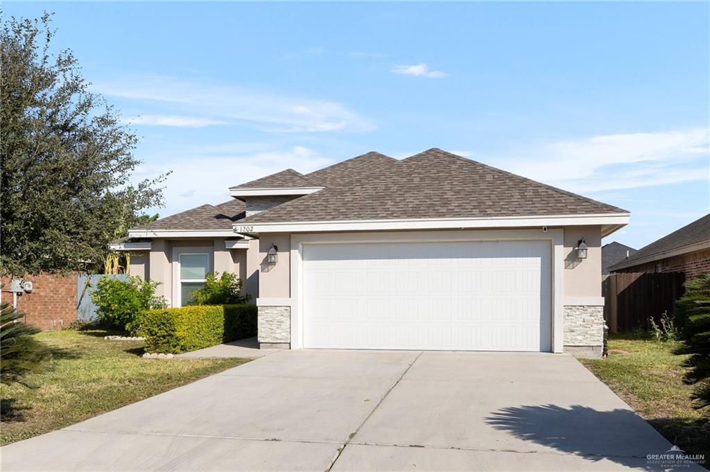 View of front of house featuring a garage and a front lawn