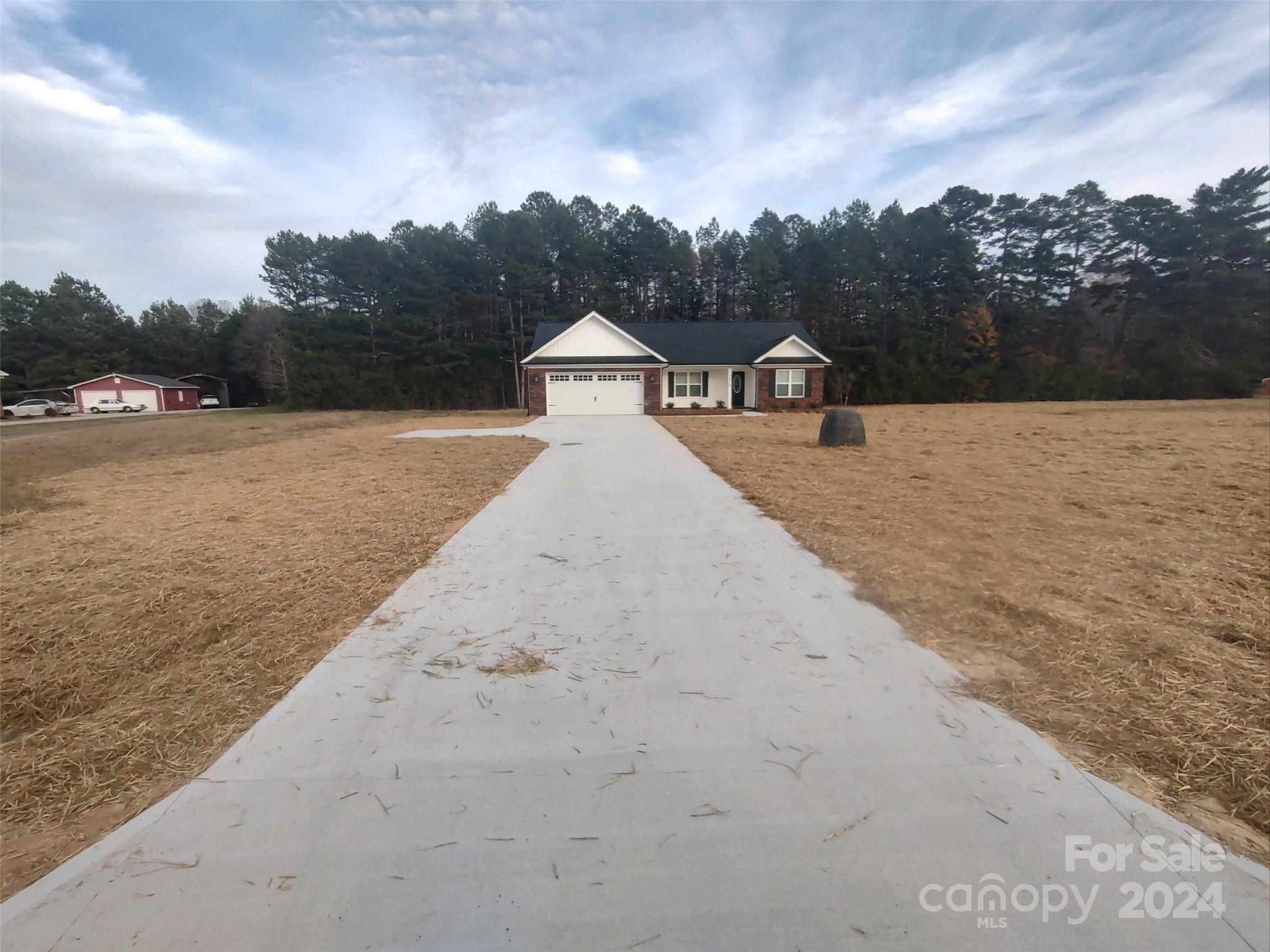 a view of a dry yard with wooden fence