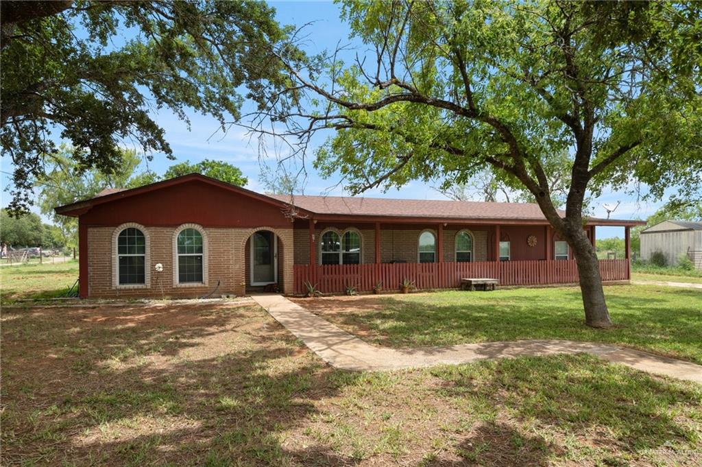 a front view of a house with yard and trees