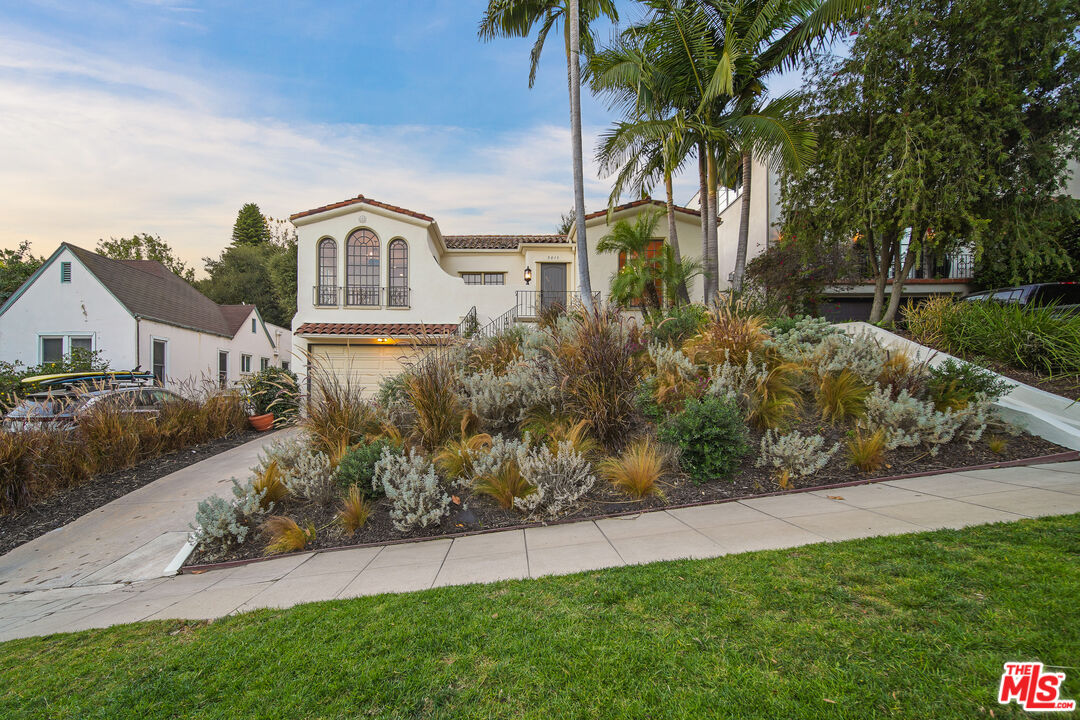 a front view of a house with a garden