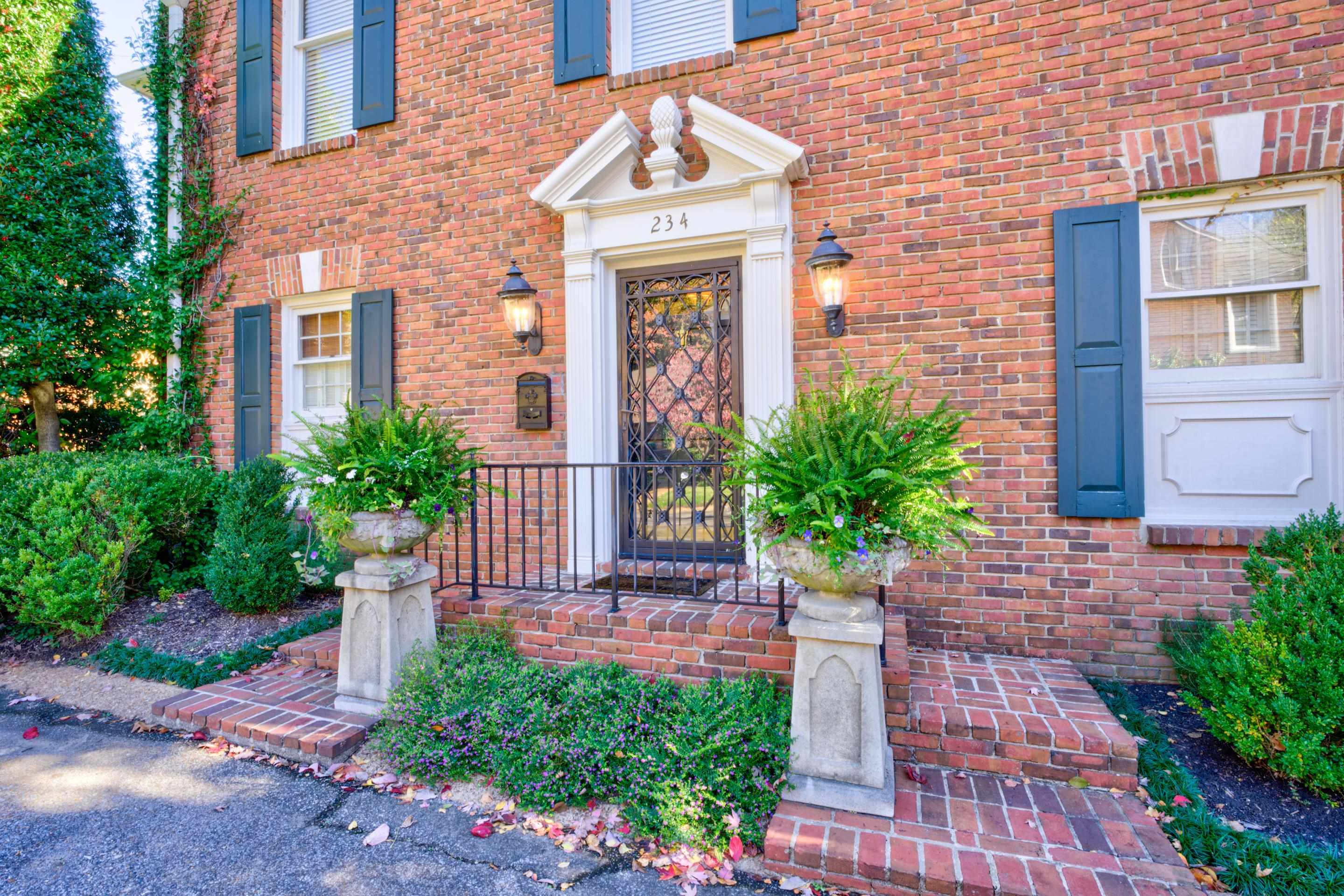 a front view of a house with plants