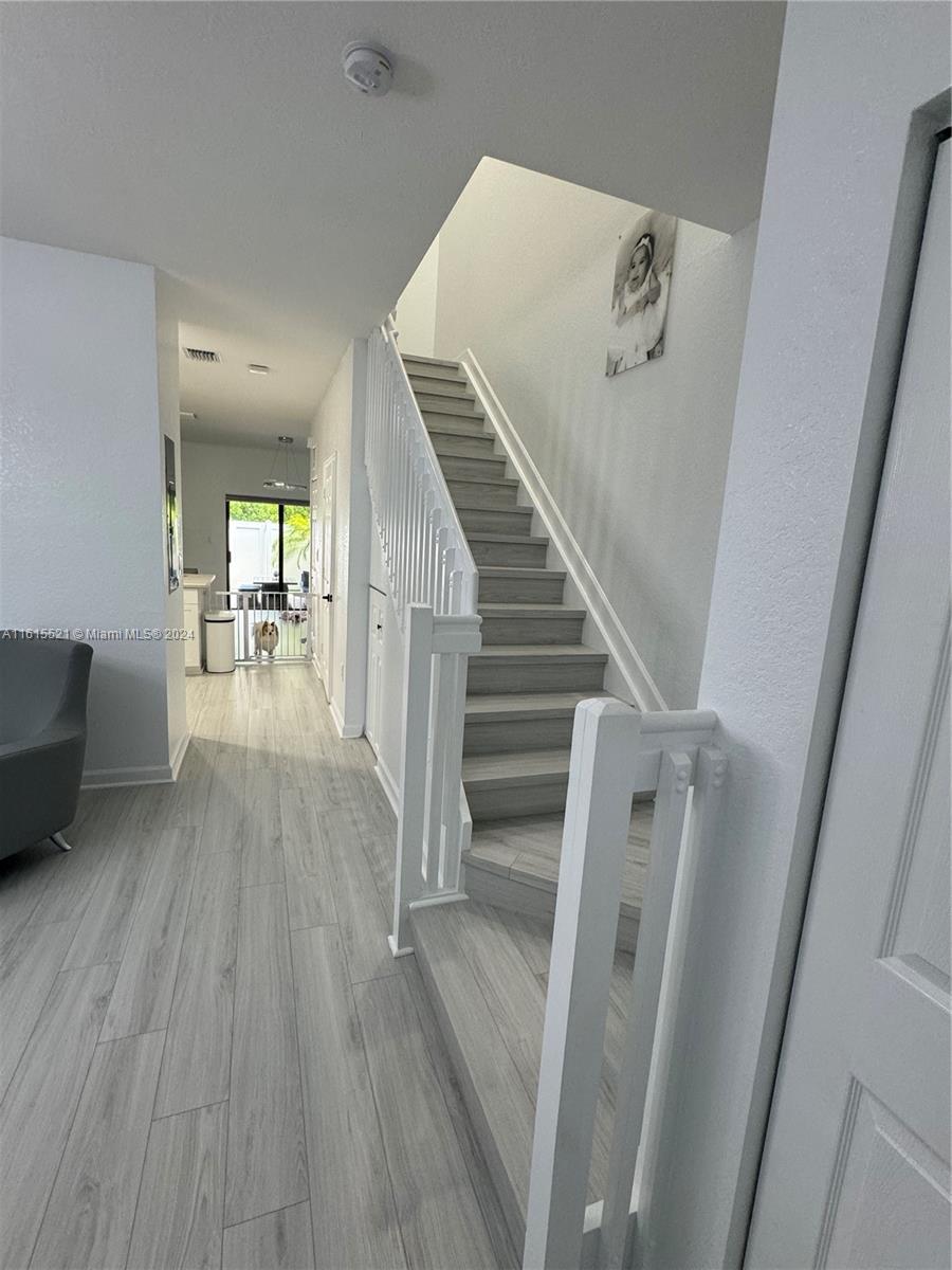 a view of a livingroom with wooden floor and stairs