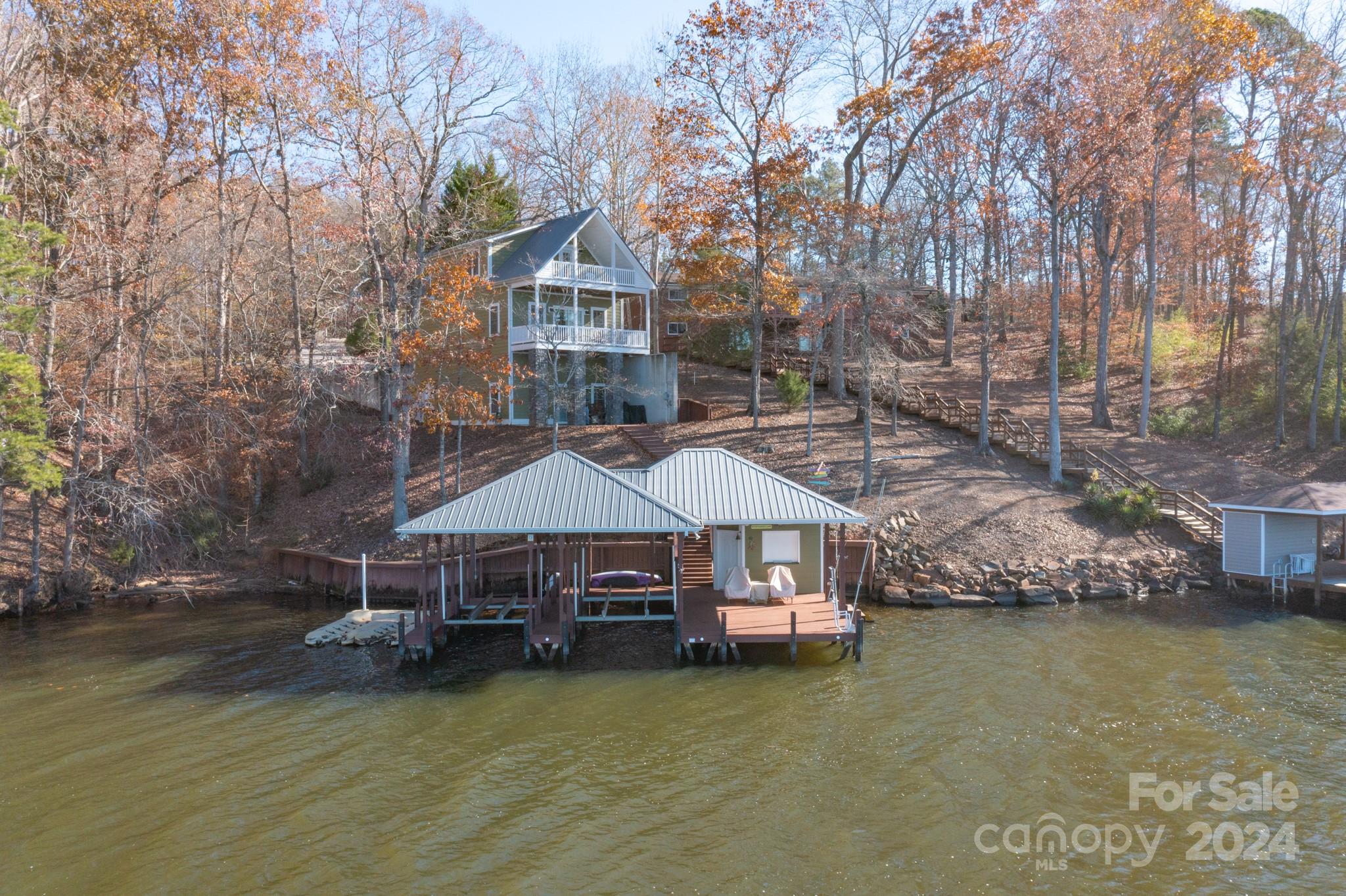 a aerial view of a house with swimming pool and large trees