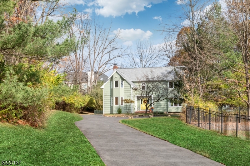 a view of a brick house with a yard and large trees