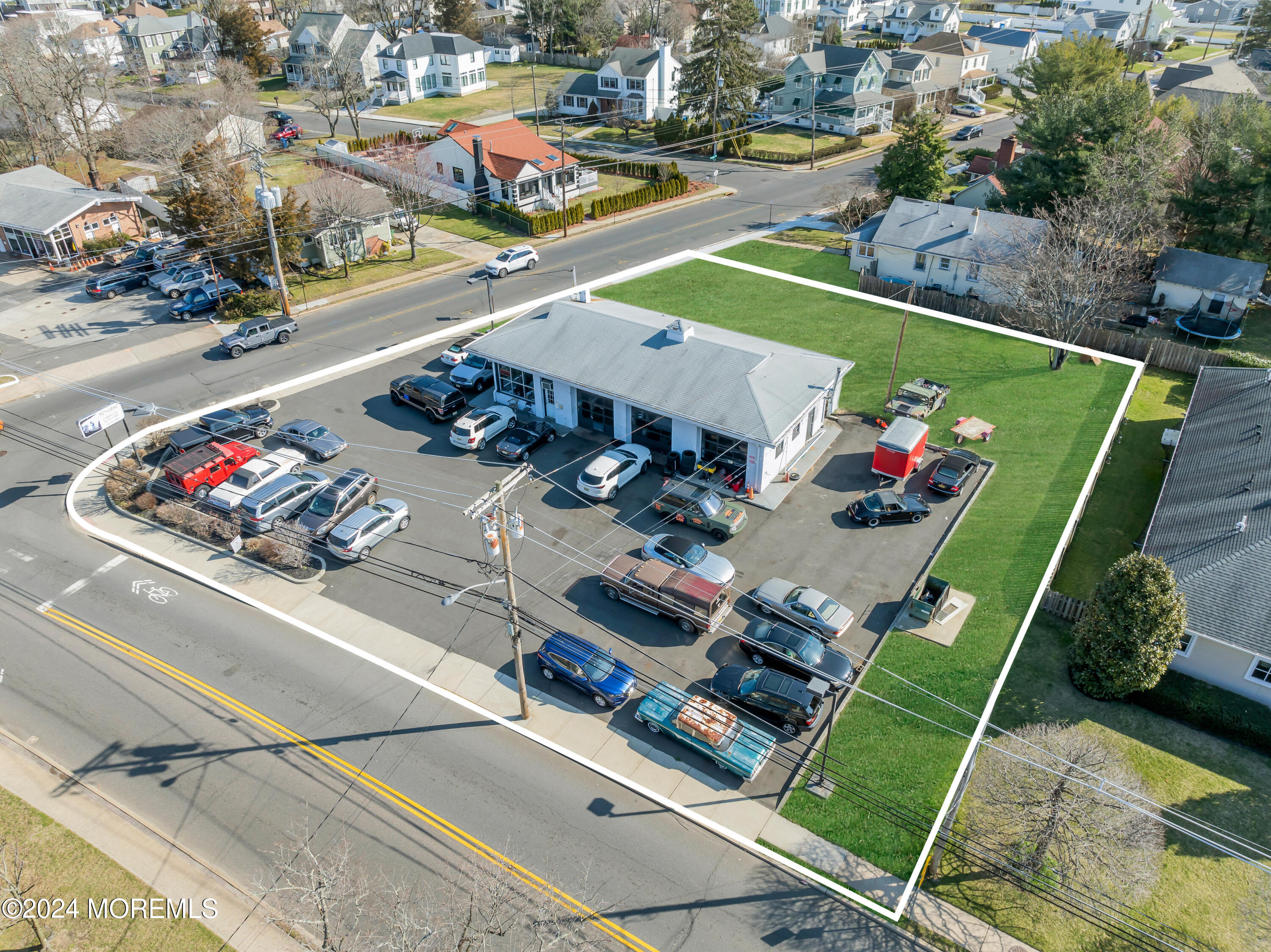 an aerial view of a tennis ground and a cars park side of the road