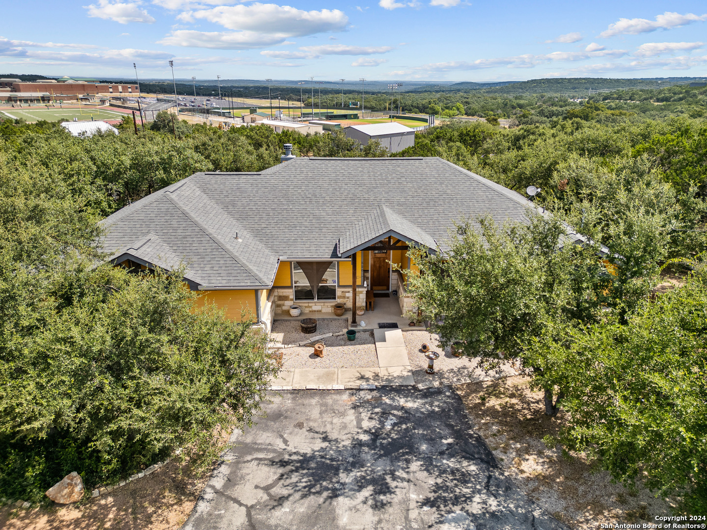 an aerial view of a house with a garden and lake view