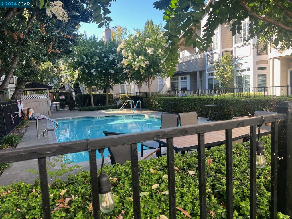 a view of a patio with table and chairs potted plants and large tree