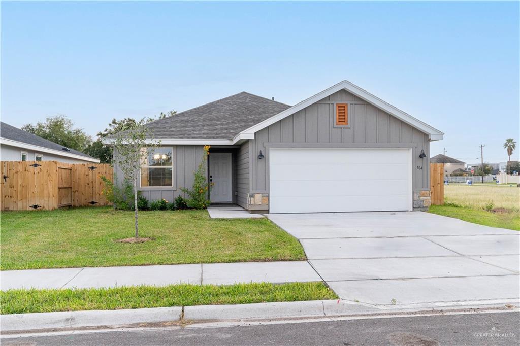 Ranch-style house with a front yard and a garage