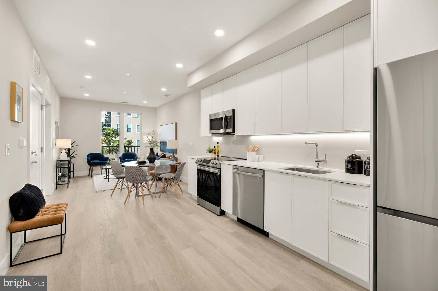 a kitchen with white cabinets and stainless steel appliances