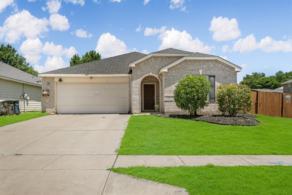 a front view of a house with a garden and yard