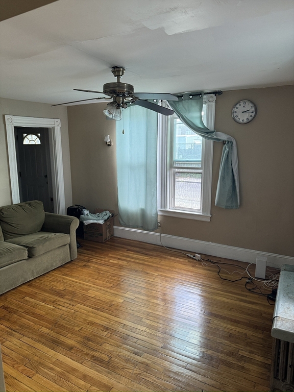 a view of a room with window a ceiling fan and wooden floor