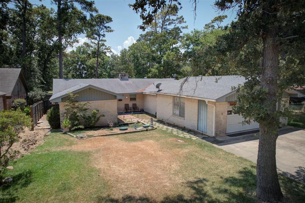 a view of a house with a yard and large tree