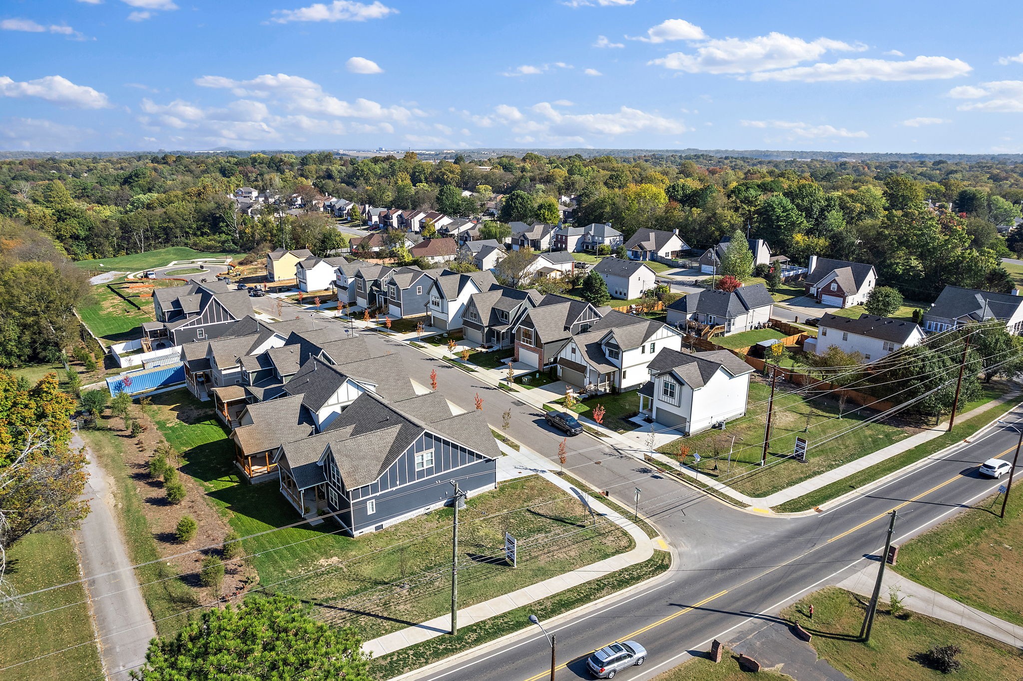 an aerial view of residential houses with outdoor space and city view