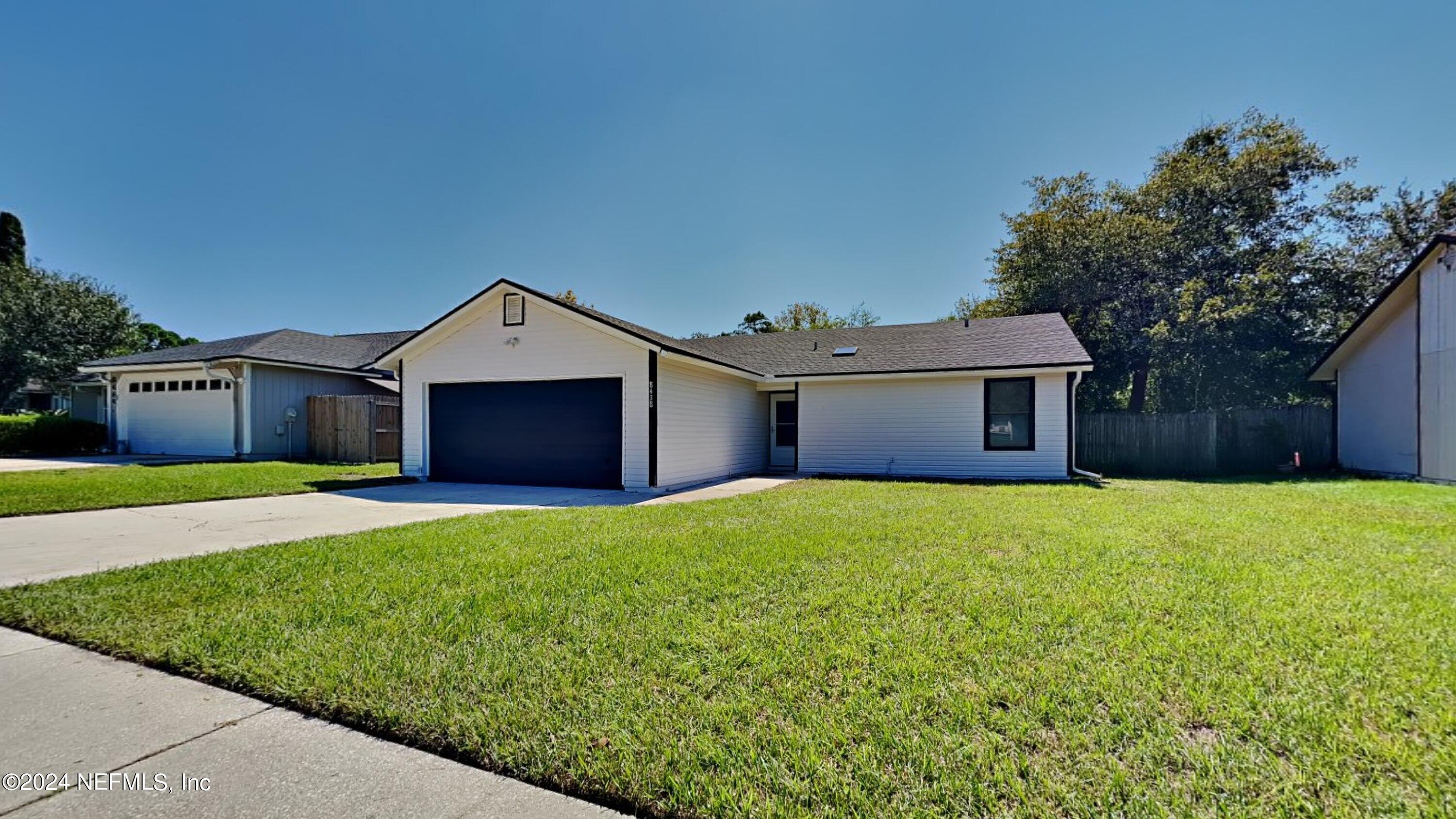 a front view of house with yard and green space