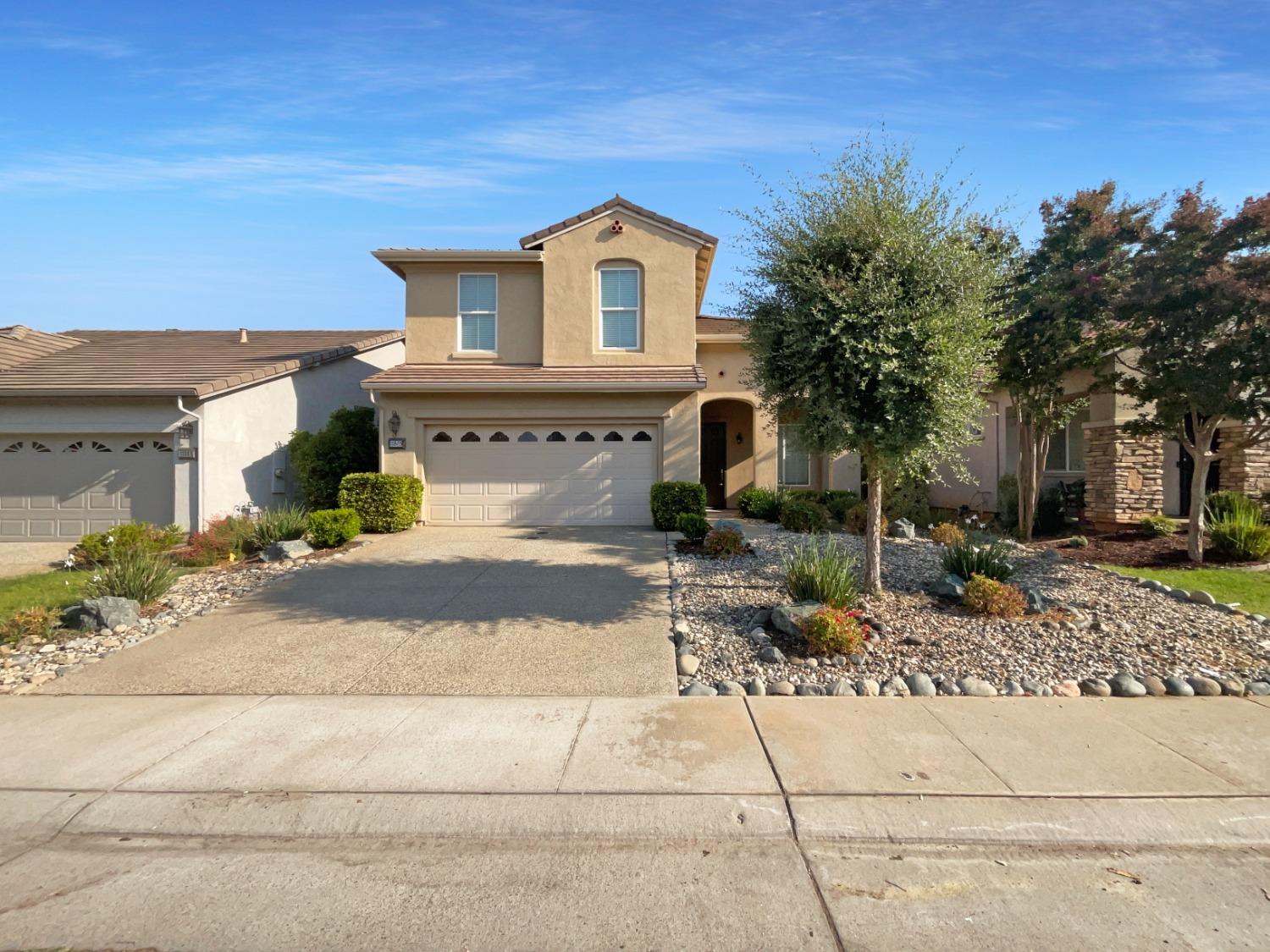 a front view of a house with a yard and garage